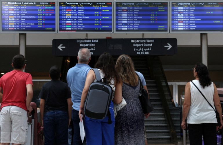 people look at an information board showing some cancelled flights, at the beirut-rafic hariri international airport, in beirut, lebanon august 25, 2024. reuters/mohamed azakir