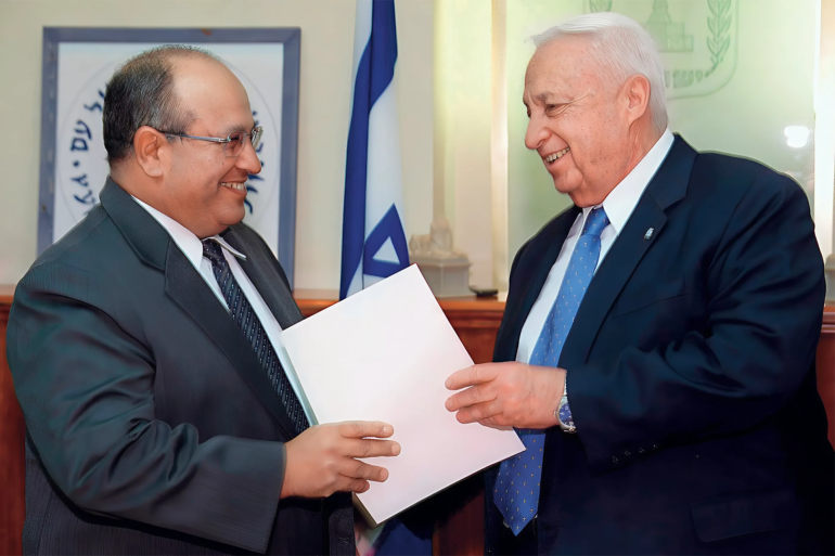 picture released 30 october 2002 by the israeli government press office (gpo) shows israeli prime minister ariel sharon (r) handing the nomination papers to the new head of mossad, israel's foreign intelligence service meir dagan, during a short ceremony at sharon's office in jerusalem. dagan, 55, replaced ephraim halevy, who was appointed sunday to head the national security council. afp photo/yakov saar-gpo (photo by yakov saar / gpo / afp)