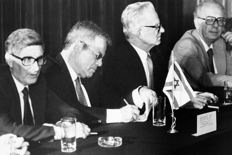 Israeli negotiators sign an agreement to send a border dispute with Egypt to international arbitration, Sept. 10, 1986, setting the stage for Thursday's summit conference at Giza, Egypt. From left: David Kimche, Avraham Tamir and Moshe Sasson. Man at far right is unidentified. (AP Photo)