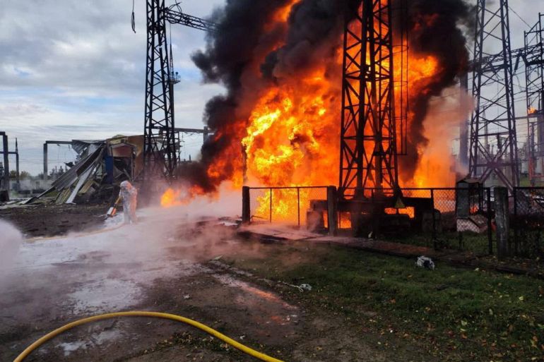 firefighters work to put out a fire at energy infrastructure facilities, damaged by a russian missile strike