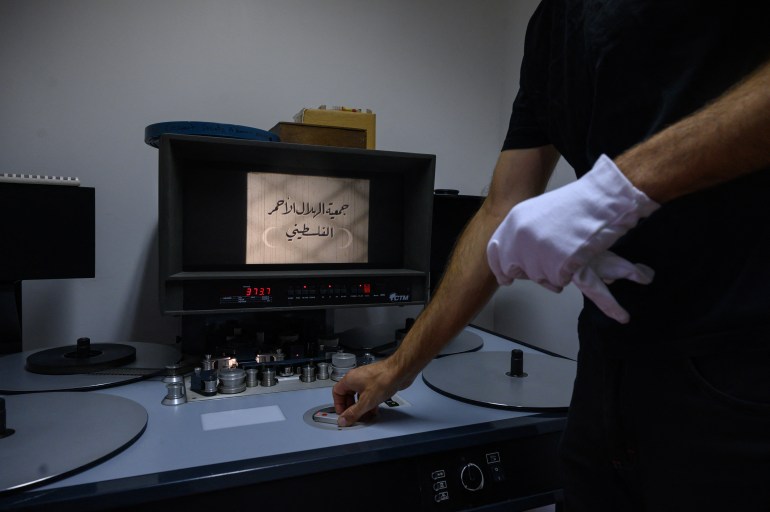 archivist matthieu larroque inspects a reel of film showing scenes of daily life in palestine, part of a collection of 40 palestinian films made between 1960 and 1980, at the conservation and research center of the toulouse cinematheque, in toulouse, southwestern france, on august 1, 2024.