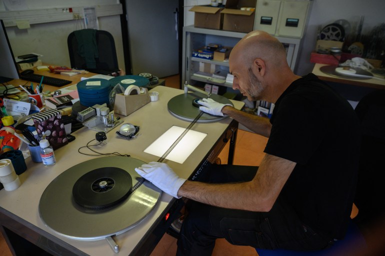 archivist matthieu larroque inspects a reel of palestinian film, part of a collection of 40 palestinian films made between 1960 and 1980, at the conservation and research center of the toulouse cinematheque, in toulouse, southwestern france, on august 1, 2024.