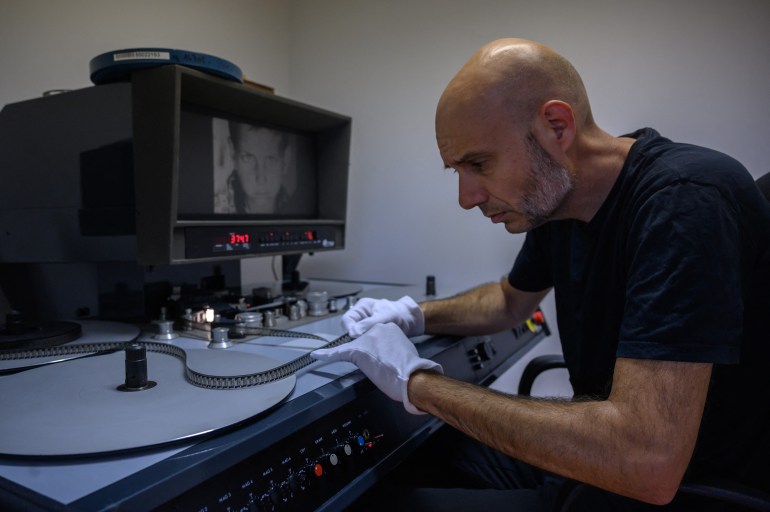 archivist matthieu larroque inspects a reel of film showing scenes of daily life in palestine, part of a collection of 40 palestinian films made between 1960 and 1980, at the conservation and research center of the toulouse cinematheque, in toulouse, southwestern france, on august 1, 2024.