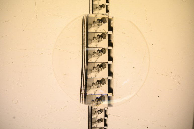 this photograph shows a reel of film showing scenes of daily life in palestine, part of a collection of 40 palestinian films made between 1960 and 1980, is displayed under a magnifying glass at the conservation and research center of the toulouse cinematheque, in toulouse, southwestern france, on august 1, 2024.