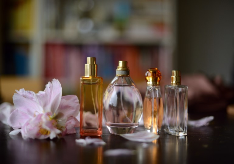 perfume bottles in summery colors and peony petals