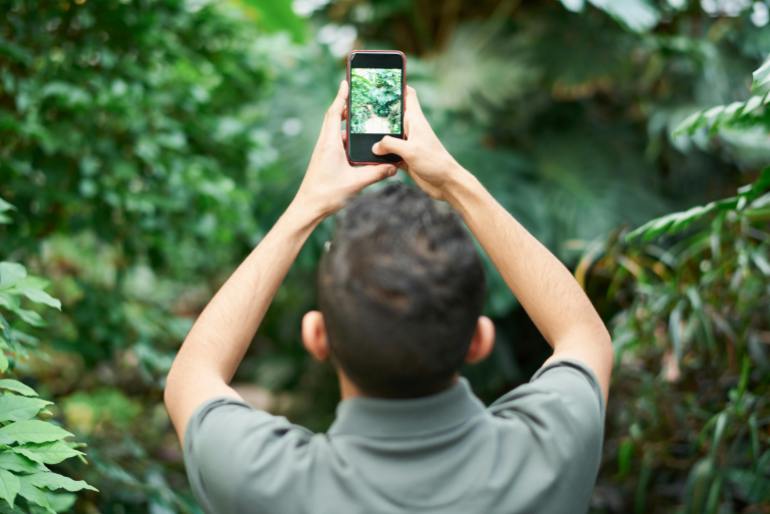 selective focus photo of man taking picture using smartphone