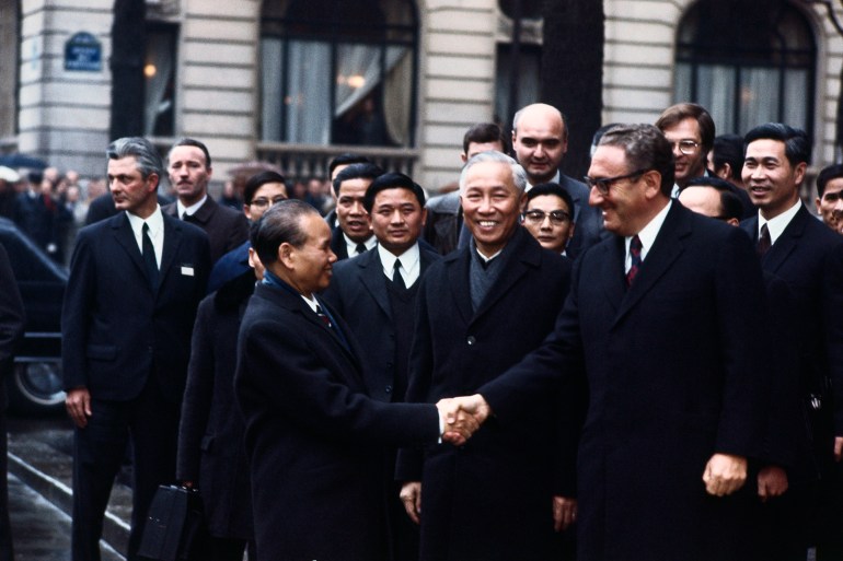 presidential adviser henry kissinger (r) and hanoi's le duc tho are all smiles as they shake hands for the press upon leaving the international conferences center here after a three hour and forty-five minute meeting on vietnam peace agreement. they are flanked by minister xuan thuy, chief of drv delegation.