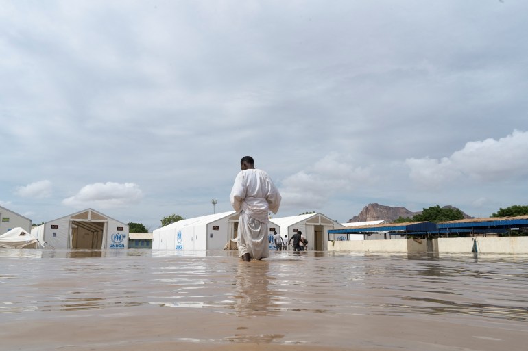 a displaced sudanese man walks towards the unhcr tent through a flooded street, following a heavy rainfall in kassala, sudan, july 26, 2024. reuters/mohamed abdulmajid