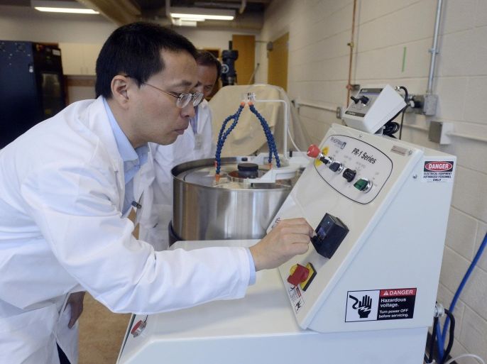 in this sept. 15, 2014 photo, yutong guan shows off a machine used to polish germanium crystals at the germanium crystal growing lab at south dakota state university ion sioux falls, s.d. research at public universities in south dakota is being squeezed by a drop-off in federal funding. the reason is an end to federal stimulus funding coupled with federal budget cuts. (ap photo/the argus leader, elisha page)