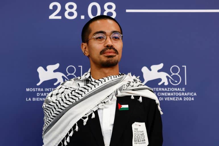 director neo sora, wearing a jacket with a palestinian flag and a keffiyeh, poses during a photocall for the movie "happyend", orizzonti competition, at the 81st venice film festival, venice, italy, september 2, 2024. reuters/yara nardi