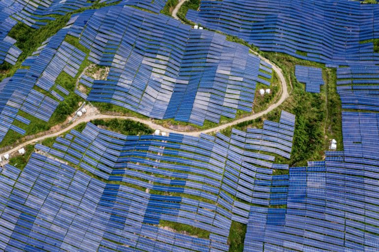 a bird’s-eye view of a large solar farm on the top of the mountain from a drone view in fujian province, china - صورة التقطت بطائرة من غير طيار لمزرعة شمسية كبيرة على قمة الجبل في مقاطعة فوجيان في الصين