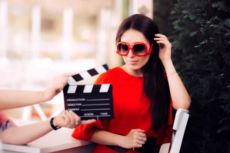 Actress with Oversized Sunglasses Shooting Movie Scene - Diva in red dress and big shades starring in an artistic film