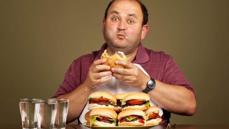 Man excited about eating a a plate full of burgers غيتي