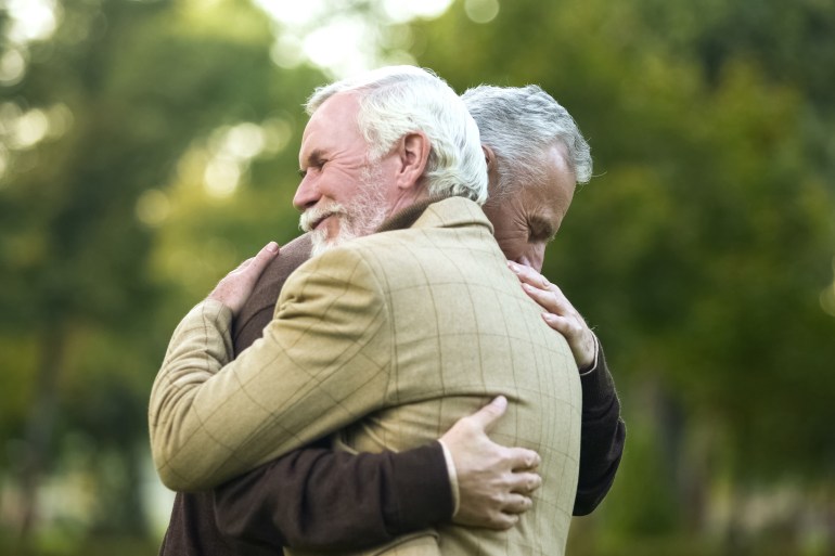 mature men hugging, happy to see each other, old friends meeting, greeting; shutterstock id 1374524774; purchase_order: aljazeera ; job: ; client: ; other: