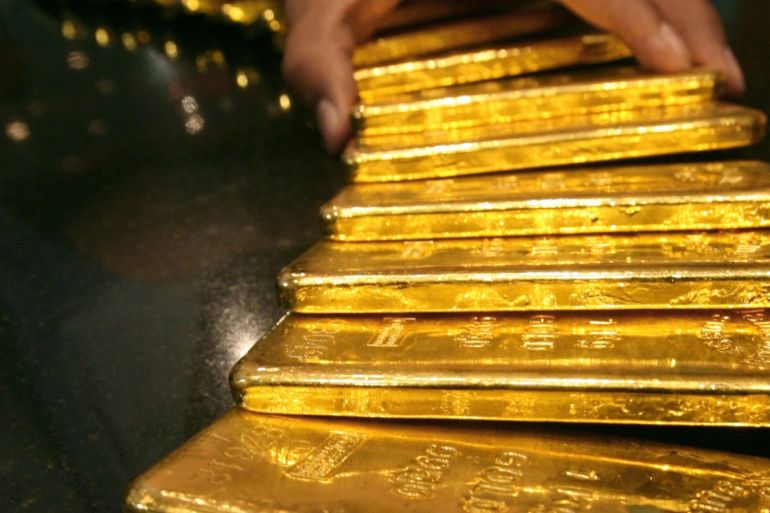 A security guard places several one-kilo gold bars inside a secured vault in Dubai April 20, 2006. Spot gold surged to a 25 year high of $645.75 on Thursday in a rally that has been driven by inflation worries, political tensions in the Middle East and instability in currency markets.   REUTERS/ Tamara Abdul Hadi