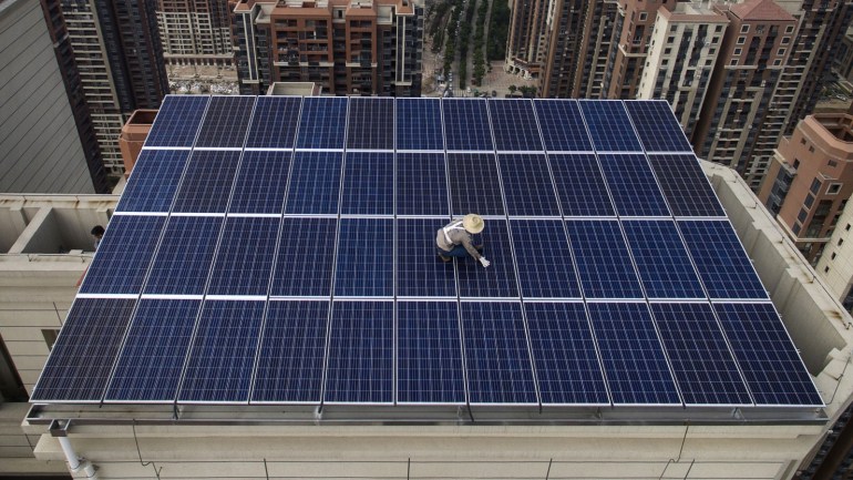 wuhan, china - may 15: a chinese worker from wuhan guangsheng photovoltaic company works on a solar panel project on the roof of a 47 story building in a new development on may 15, 2017 in wuhan, china. china consumes more electricity than any other nation, but it is also the world's biggest producer of solar energy. capacity in china hit 77 gigawatts in 2016 which helped a 50% jump in solar power growth worldwide. china is now home to two-thirds of the world's solar