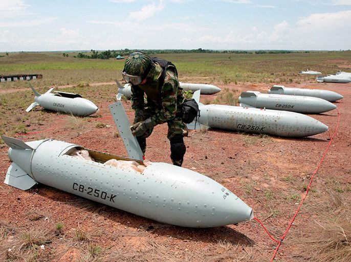 المسوعة -- epa01722741 a member of the colombian air force checks a cluster bomb before its destruction near the village of marandua, vichada department, colombia, 07 may 2009. cluster bombs are being destroyed in accordance with the oslo agreement. epa/mauricio duenas