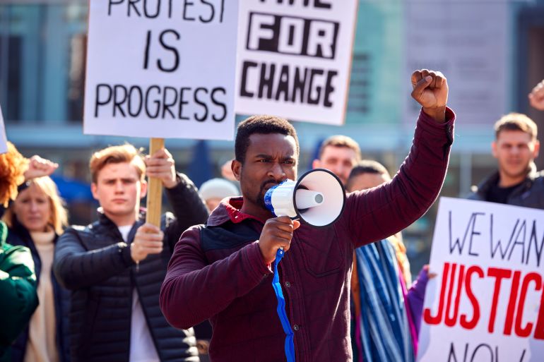 protestors with placards and megaphone on protests demonstration march against racism