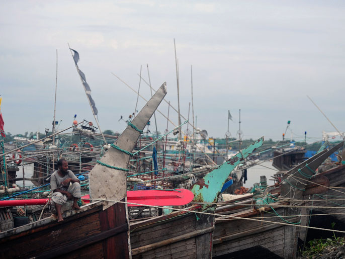 chittagong, -, bangladesh : a bangladeshi fisherman sits on a fishing boat tied up in the harbour of chittagong on may 15, 2013 during preparations for the expected arrival of cyclone mahasen. cyclone mahasen is moving northeastwards over the bay of bengal and expected to make landfall on may 17 morning north of the bangladeshi city of chittagong, sparing myanmar's restive rakhine state from its full fury, the un said. afp photo/ munir uz zaman