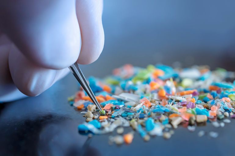 macro shot of a person with medical gloves and tweezers inspecting a pile of micro plastics. concept of water pollution and global warming. macro shot of micro plastics. cool blue filter applied.; shutterstock id 2309914391; purchase_order: aja; job: ; client: ; other: