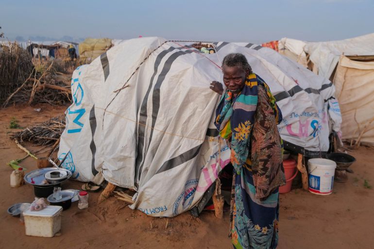 امرأة سودانية، خديجة عيسى خميس، 90 عامًا، هربت من النزاع في جنيينة، دارفور، تتجول خارج مأواها المؤقت في أدري بتشاد. (رويترز)