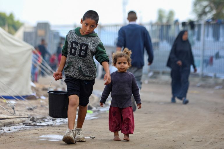 children walk amid tents as palestinians displaced by the israeli military offensive take shelter at a tent camp set up on a damaged soccer stadium, in gaza city november 10, 2024. reuters/dawoud abu alkas