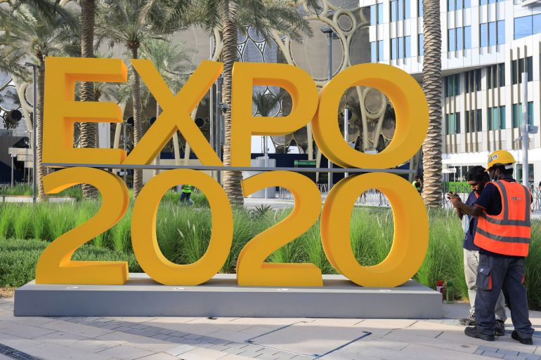 workers are pictured next to the expo 2020 logo ahead of the opening ceremony in dubai, united arab emirates, september 30, 2021. reuters/rula rouhana