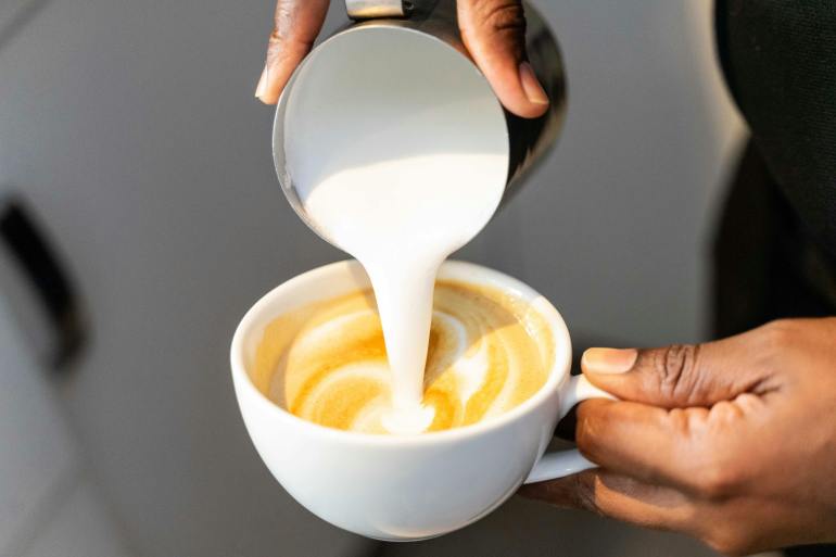 barista crafting a perfect latte with steamed milk