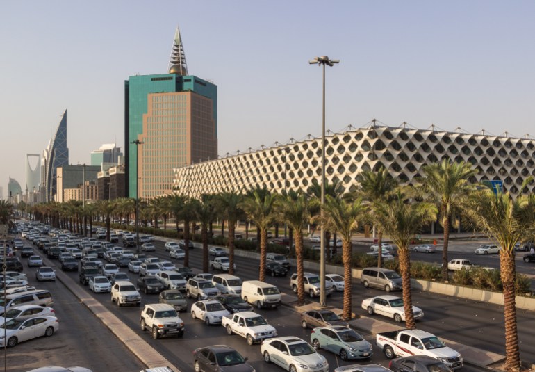 riyadh, saudi arabia - october 15, 2015. traffic jam on king fahd road in riyadh full of white cars and taxi near riyadh national library with al faisaliah tower and kigdom tower in back