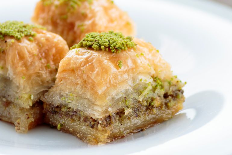 baklava with pistachios and walnuts on white plate. shallow depth of field