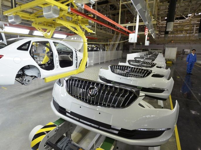 An employee looks on next to an assembly production line of Buick cars at a General Motors factory in Wuhan, Hubei province January 28, 2015.