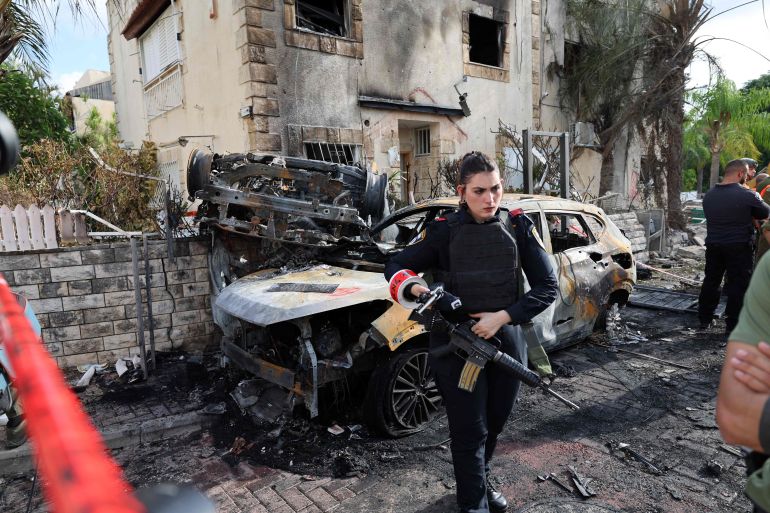 TOPSHOT - A member of the Israeli security forces stands guard inside a cordoned-off area in Kiryat Bialik in the Haifa district of Israel, targeted by a reported strike by Lebanon's Hezbollah on September 22, 2024. Hezbollah said on September 22 that it targeted military production facilities and an air base near north Israel's Haifa after the Israeli military pounded south Lebanon and said it targeted thousands of rocket launcher barrels. (Photo by Jack GUEZ / AFP)