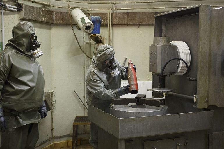 (FILES) This photo taken on October 30, 2013, shows employees in protective gear preparing to dismantle a dummy grenade during a demonstration at a chemical weapons disposal facility of GEKA (Gesellschaft zur Entsorgung von chemischen Kampfstoffen und Ruestungsaltlasten) in Munster, northern Germany. Syria has surrendered or destroyed nearly a third of its chemical arsenal but remains behind on its international obligations, the head of the disarmament mission told the world's chemical watchdog on March 4, 2014. Syria has already missed several target dates to hand over or destroy its arsenal before a June 30 deadline and the United Nations-Organisation for the Prohibition of Chemical Weapons (OPCW) mission called on Damascus to move faster. AFP PHOTO / PHILIPP GUELLAND