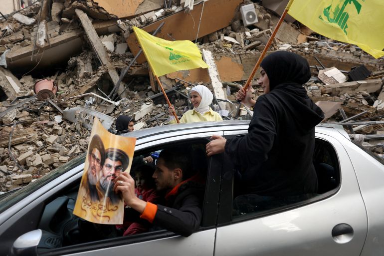 صورة أرشيفية: نساء يحملن أعلام حزب الله أثناء مرورهن بجانب مبنى تضرر في المدخل الجنوبي لبيروت بعد دخول اتفاق وقف إطلاق النار بين إسرائيل وحزب الله حيّز التنفيذ، لبنان 27 نوفمبر 2024. رويترز/محمد زكريا/صورة أرشيفية