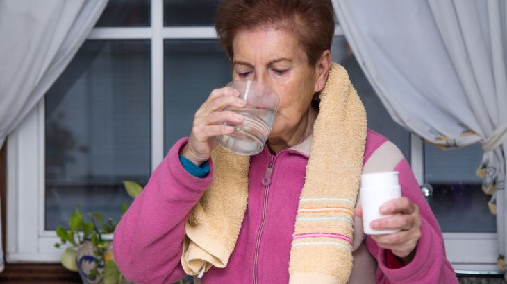 senior woman taking vitamins and supplements after sports, health and sport concept