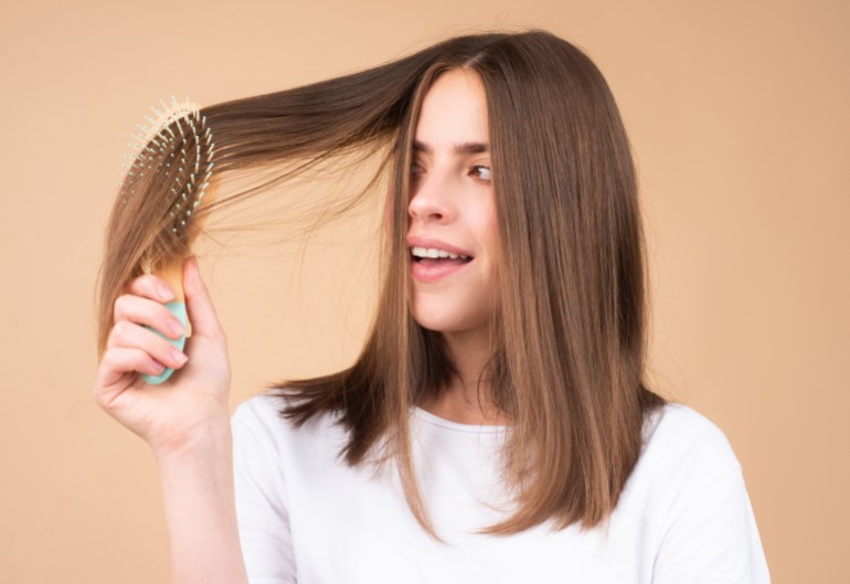 Portrait of charming brunette hair lady combing hair with hairbrush comb, isolated. Young beautiful woman brush long healthy brunette hair, classic hairstyle, restoration mask, haircare concept.