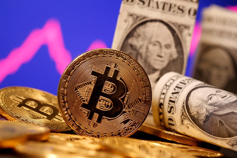 2021-12-23T201848Z_1454155419_RC2KKR9KI3RY_RTRMADP_3_SEC-BITCOIN FILE PHOTO: A representation of virtual currency Bitcoin and U.S. One Dollar banknotes are seen in front of a stock graph in this illustration taken January 8, 2021. REUTERS/Dado Ruvic/File Photo