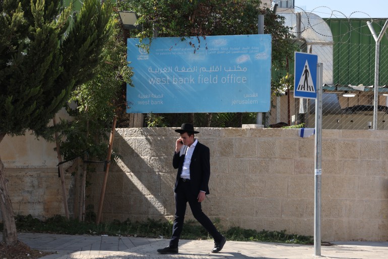 epa11690220 A man walks past the United Nations Relief and Works Agency for Palestine Refugees in the Near East (UNRWA) offices in Jerusalem. The Israeli parliament, during its winter legislative session, passed a law prohibiting UNRWA from operating within Israeli territory. Unprecedented move described by UNRWA Commissioner-General Philippe Lazzarini as a violation of UN Charter and international law.