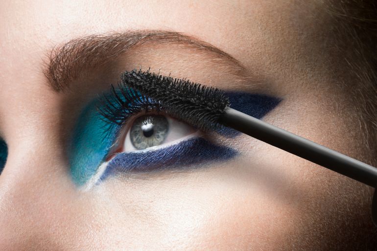 Female applying mascara, close up