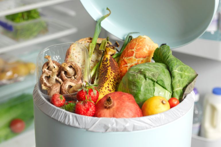 Out of date rotting food in dustbin - stock photo