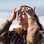 Young woman applying sunscreen on her face in snowy mountains in winter, in Sierra Nevada, Granada, Spain. Female wearing winter clothes.; Shutterstock ID 1516973336; purchase_order: aj; job: ; client: ; other: