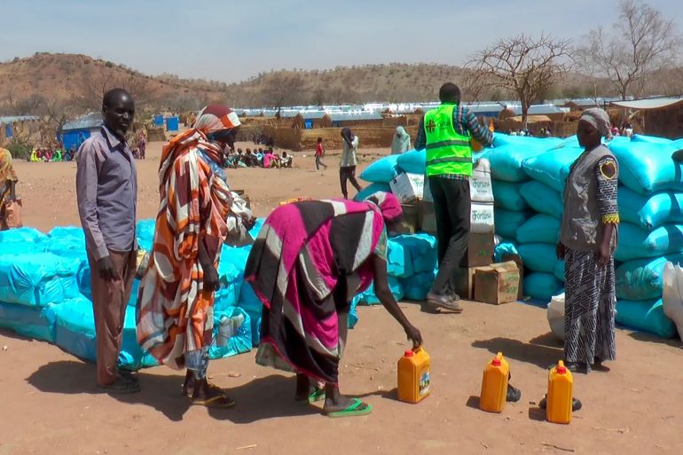 لاجئون بسبب الحرب في السودان يتلقون الغذاء في أحد المخيمات (أسوشيتد برس)