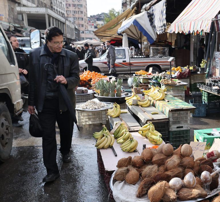 A vendor waits for customers at his stall in Damascus on December 28, 2024. (Photo by ANWAR AMRO / AFP)