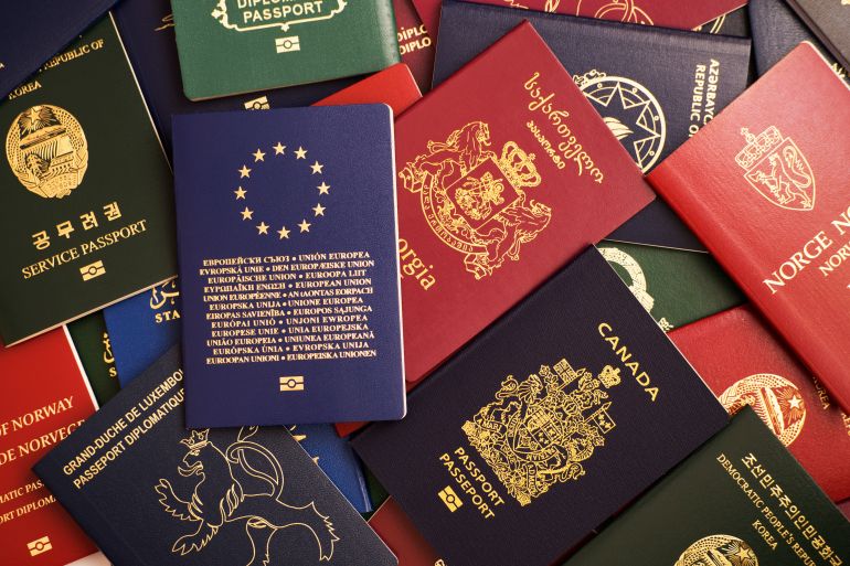 Mixed biometric passports of many countries of the world. In the foreground is a European Union passport. المصدر: ادوبي ستوك