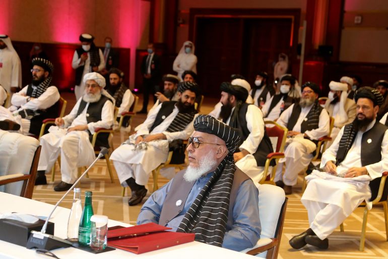 FILE - In this Sept. 12, 2020, file photo, Taliban negotiator Abbas Stanikzai, center front, and his delegation attend the opening session of peace talks between the Afghan government and the Taliban, in Doha, Qatar. Afghan negotiators are to resume talks Tuesday, Jan. 5, 2021, aimed at finding an end to the decades of relentless conflict, even as hopes are waning, and frustration and fear is growing over a spike in violence that has combatants on both sides blaming the other. (AP Photo/Hussein Sayed, File)