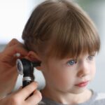 Otorhinolaryngologist examines little girl's ear with otoscope. Adenoiditis as cause of otitis media in children concept.; Shutterstock ID 2445704843; purchase_order: aj; job: ; client: ; other: