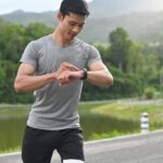 Young Asian athlete man using smartwatch to monitor his activity and progress and track good habits.